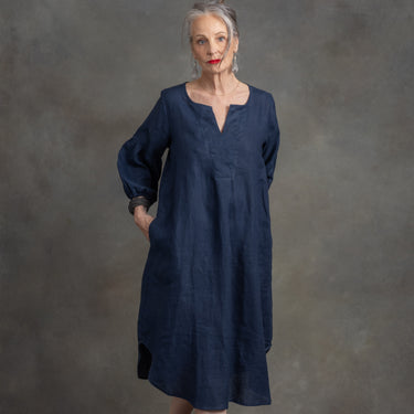 Woman wearing a blue dress against a gray background