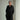 Person wearing a black dress against a white background